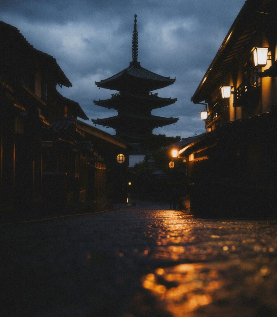 Japońska pagoda w Kioto nocą podczas deszczu z oświetloną świątynią